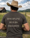 Cowboy wearing Discipline Builds Freedom western graphic tee in country setting