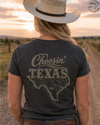 Cowgirl wearing Choosin Texas western graphic tee at sunset in country setting