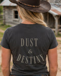 Cowgirl wearing Dust and Destiny western graphic tee in rustic country setting