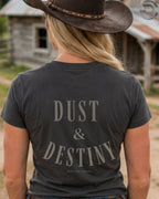 Cowgirl wearing Dust and Destiny western graphic tee in rustic country setting