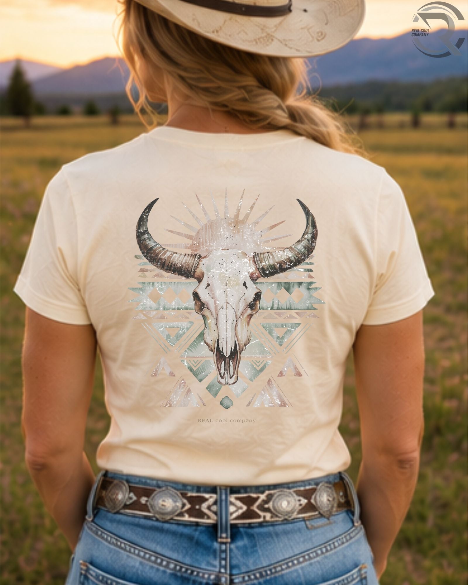 Cowgirl wearing boho bull skull western graphic tee in sunset country field